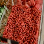 An assortment of goji berries and other dried fruits in a market container.