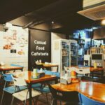 A cozy casual cafeteria interior with tables and chairs, located in Busan, South Korea.